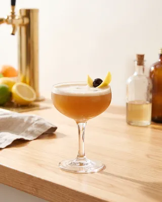 Boston Sour in a coupe with lemon and a cocktail cherry