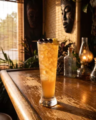 Three Dots and a Dash in a pilsner glass with cherries and pineapple