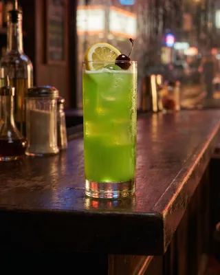 Tokyo Iced Tea in a highball glass with lemon and a cocktail cherry