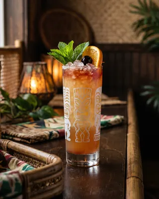 Zombie in a tiki mug with mint, a cocktail cherry and orange