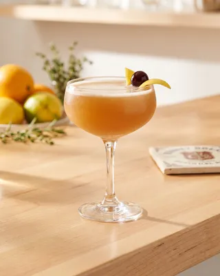 Vodka Sour in a coupe with lemon and a cocktail cherry