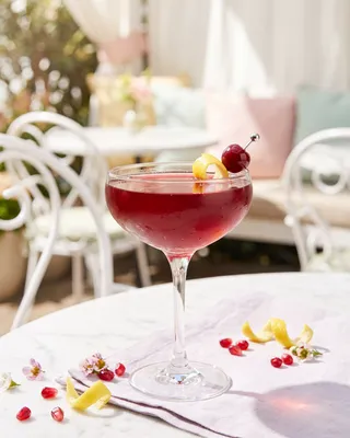 Pink & Bubbly in a coupe with lemon and a cocktail cherry