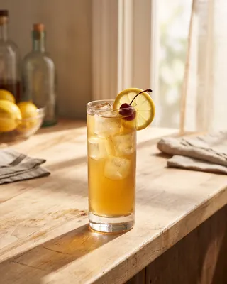 John Collins in a Collins glass with lemon and a cocktail cherry