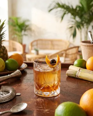 Rum Old Fashioned in a rocks glass with orange and a cocktail cherry