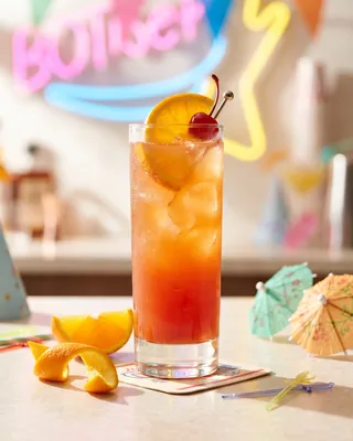 Alabama Slammer in a Collins glass with orange and a cocktail cherry