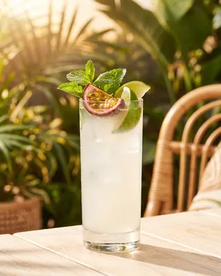 Passion Fruit Mojito in a highball glass with mint, passion fruit and lime
