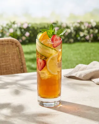 Pimm's Cup in a Collins glass with cucumber, orange, lemon, strawberry and mint